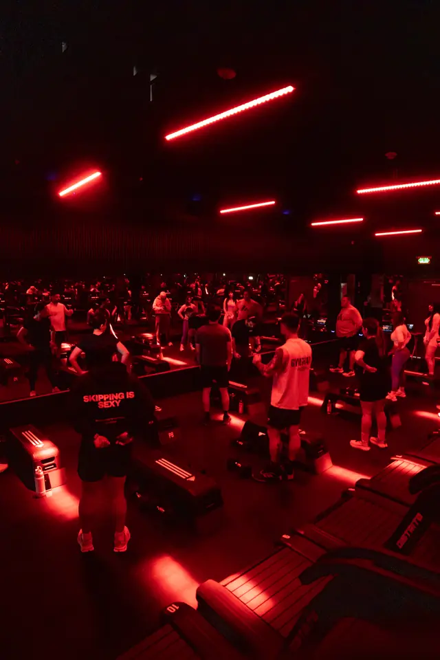 Clase llena en Distrito Calzada bajo tubos de luz roja